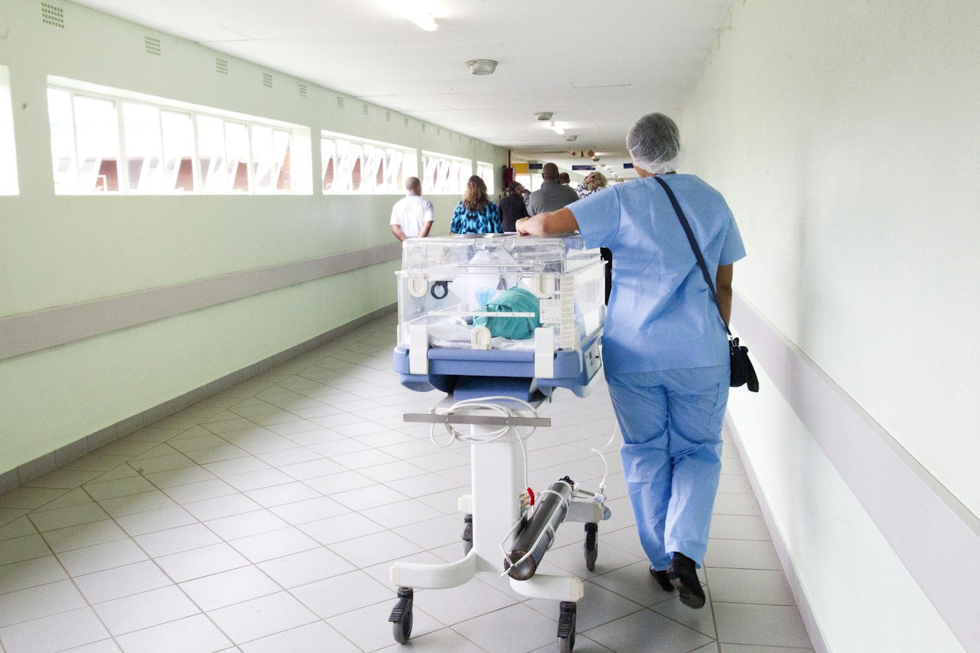 Clinician in scrubs walking through a hospital ward
