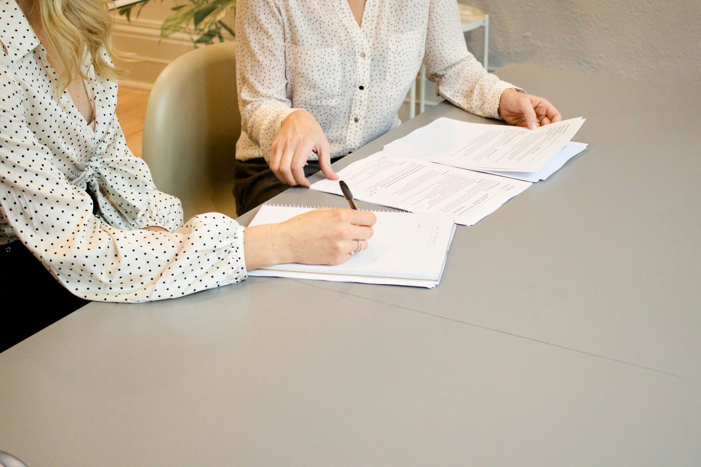 Customer signing a document while an agent points to the paperwork
