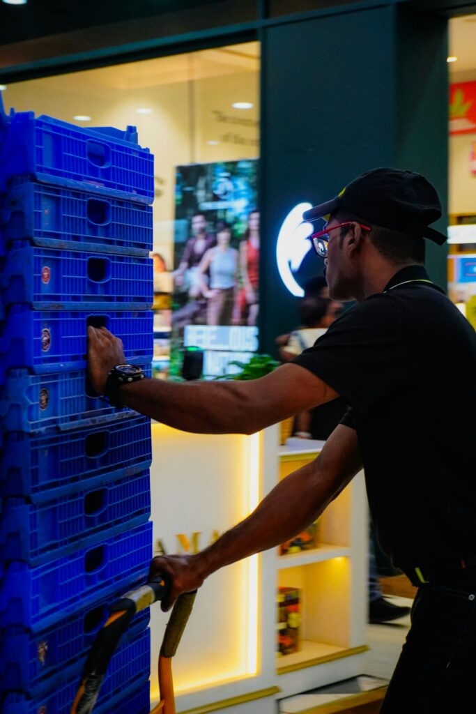 Retail worker moving stock crates on a trolley
